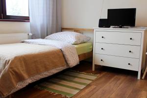 a bedroom with a bed and a dresser with a television at Apartment Polianka in Vysoké Tatry