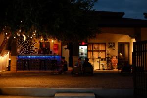two people sitting in chairs outside of a house at night at Pure's Place in Khanom