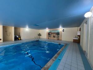 a large swimming pool with a blue ceiling at 3 bedroom barn conversion with swimming pool, tennis court and more! in Kingsbridge