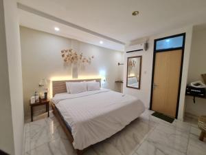 ein Schlafzimmer mit einem großen weißen Bett in einem Zimmer in der Unterkunft La bianca Home in Kota