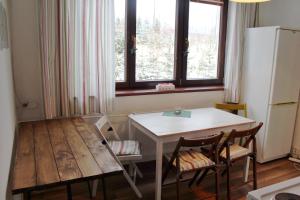 a kitchen with a table and a table and a refrigerator at Apartment Polianka in Vysoké Tatry