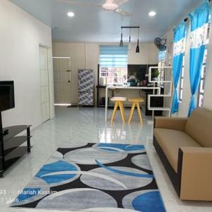 a living room with a couch and a kitchen at MKF Homestay Padang Stang, Gerik in Gerik