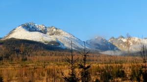 a mountain range with snow covered mountains in a field at Apartment Polianka in Vysoke Tatry - Horny Smokovec