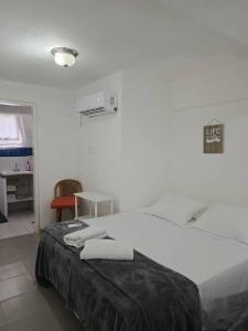 Dieses weiße Zimmer verfügt über ein Bett und einen Schreibtisch. in der Unterkunft Tucacas Penthouse w Generator and Water Tank in Tucacas