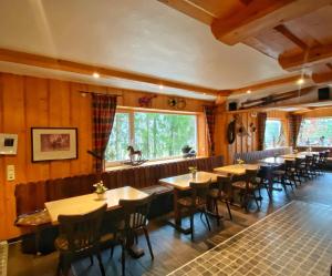 a restaurant with wooden tables and chairs and a window at Skihütte Ettelsberg in Willingen