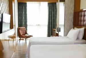 A bed or beds in a room at The Hera Platinum Hotel