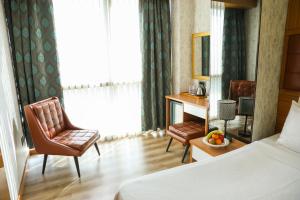 A bed or beds in a room at The Hera Platinum Hotel