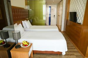A bed or beds in a room at The Hera Platinum Hotel