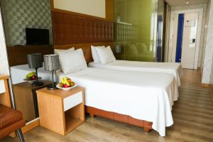 A bed or beds in a room at The Hera Platinum Hotel