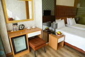 A bed or beds in a room at The Hera Platinum Hotel