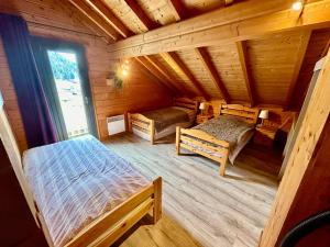 Habitación con 2 camas en una cabaña de madera en Chalet Le Roncing, en Gérardmer