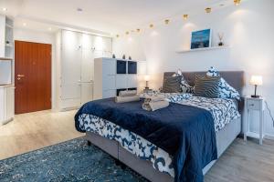 ヴンストルフにあるKapitäns Kajüte am Steinhuder Meerの青と白のシーツが敷かれた大きなベッドのある寝室