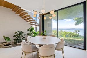 een eetkamer met een tafel en stoelen en een groot raam bij Luxurious Villa in Papagayo in Nacascolo