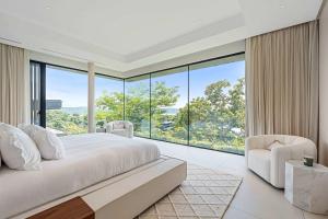 een slaapkamer met een groot bed en een groot raam bij Luxurious Villa in Papagayo in Nacascolo +63 foto's