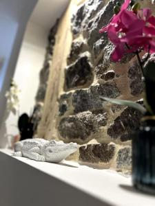a flower on a shelf next to a stone wall at le privilège - 400m de la gare in Saint-Brieuc