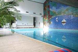 a swimming pool with a mural on the wall at Sporthotel Schulenberg in Schulenberg im Oberharz