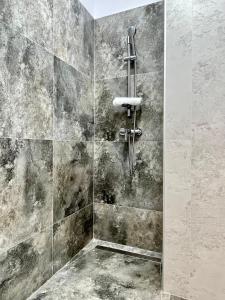 a bathroom with a shower with a stone wall at Apartment No 604 Central Residence in Bucharest +16 photos
