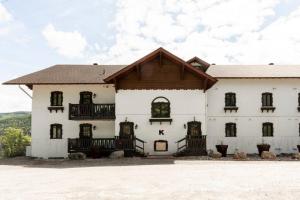 a white building with a wooden roof and windows at InstantSuites- The Mountain Lake house in Mont-Tremblant
