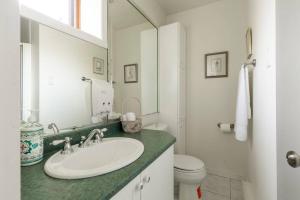 a white bathroom with a sink and a toilet at InstantSuites- The Mountain Lake house in Mont-Tremblant +18 photos