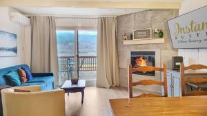 a living room with a blue couch and a fireplace at InstantSuites- The Mountain Lake house in Mont-Tremblant
