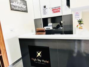 a reception desk with a high sky hotel sign on it at Hotel High Sky in Rohtak