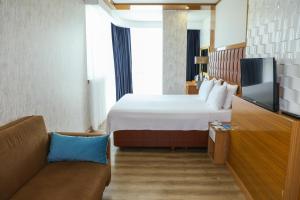 A bed or beds in a room at The Hera Platinum Hotel