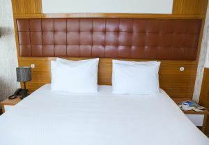 A bed or beds in a room at The Hera Platinum Hotel