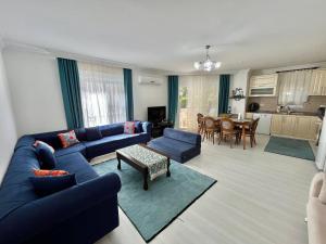 a living room with a blue couch and a table at Manolyam suit havuzlu 2+1 in Kaş