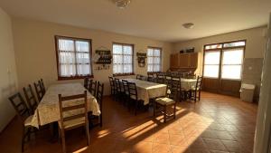 a kitchen and dining room with tables and chairs at Bozsity Vendégház in Üllés