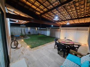 an outdoor patio with a table and chairs and a room at Piscina, lazer e diversão em Cabo Frio in Cabo Frio