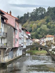 a river in a town with buildings and a bridge at San Bartolome Etxea 1 in Ea