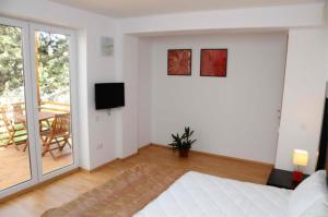 Dieses weiße Zimmer verfügt über ein Bett und einen Balkon. in der Unterkunft Vila Cube in Eforie Nord