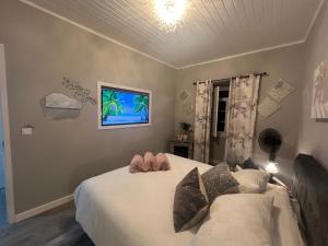 Un dormitorio con una cama y un televisor en la pared. en Santa Maria , Azores, en Vila do Porto