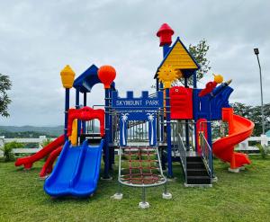 a playground park with a slide and a play structure at SkyMount Resort in Tanay