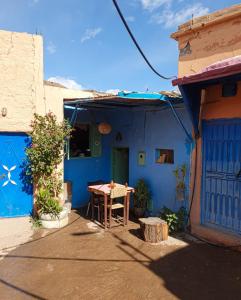 a blue building with a table in front of it at Adil Guest House in Nzala