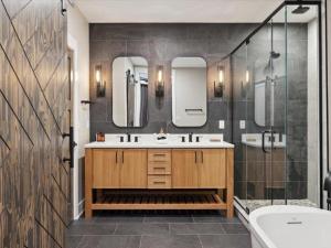 a bathroom with a sink and two mirrors and a tub at Highlands of the Smokies 210 3br in Gatlinburg +40 photos