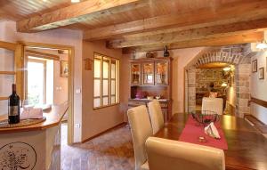 a kitchen and dining room with a wooden table and chairs at 2 Bedroom Lovely Home In Kanfanar in Kanfanar