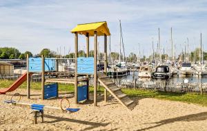 a playground with a slide in the sand near a marina at Kaapstad in Naarden +19 photos
