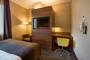 Cette chambre comprend un lit, un bureau et une télévision. dans l'établissement Holiday Inn Istanbul - Kadikoy, an IHG Hotel, à Istanbul