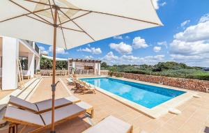 a villa with a swimming pool and an umbrella at Casa Vistamar in S'Estanyol de Migjorn
