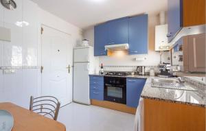 eine Küche mit blauen Schränken und einem weißen Kühlschrank in der Unterkunft 3 Bedroom Lovely Home In Cartagena in Cartagena