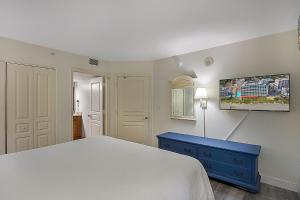 a bedroom with a white bed and a blue dresser at Seas the View at Ocean Reef Resort #320 in Myrtle Beach