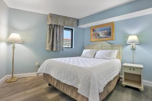 a bedroom with a bed with blue walls and a window at Seas the View at Ocean Reef Resort #320 in Myrtle Beach +17 photos