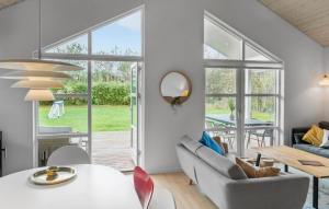 a living room with a table and chairs and a window at Lovely Home In Dannemare With Sauna in Dannemare