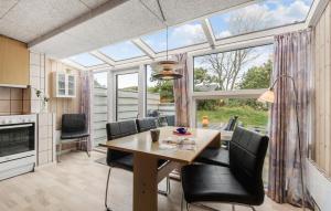 a dining room with a table and chairs and a large window at Stunning Apartment In Vejers Strand in Vejers Strand