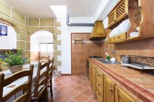 a kitchen with a sink and a counter with wooden cabinets at OkStay Beach House Las Maretas Tenerife in Arico