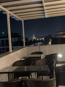 un patio all'ultimo piano con tavoli e sedie di notte di Little Buddha Inn a Kathmandu