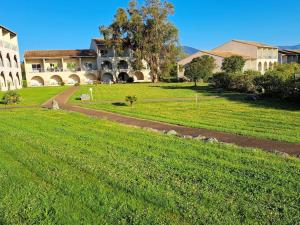 une grande cour avec une maison et une pelouse dans l'établissement Appartement avec piscine à 2 pas de la plage, à Linguizzetta