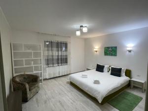 a small bedroom with a bed and a chair at Holidays Home 4 You in Rădăuţi