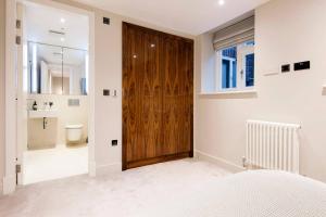 ein Schlafzimmer mit Holztür und ein Badezimmer in der Unterkunft Home Sweet Hampstead Heath in London + 18 Fotos
